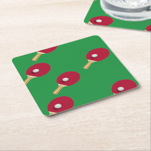 Table tennis racket and ball on green square paper coaster