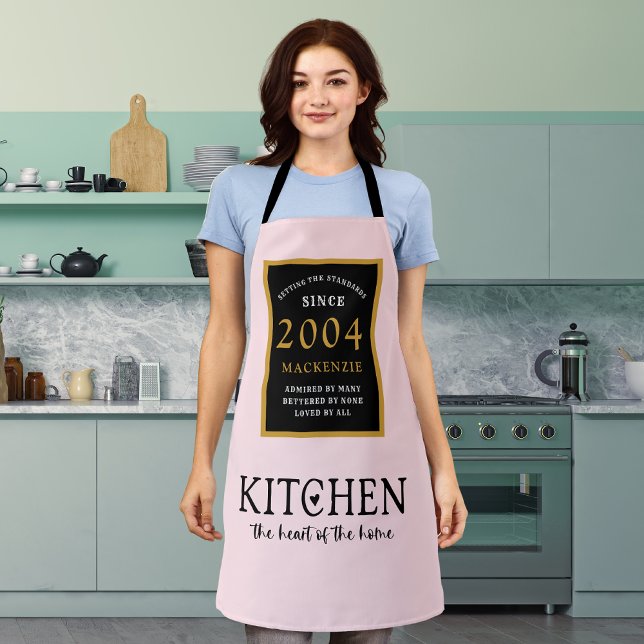 Tablier 21e Anniversaire 2004 Nom Cuisine Rose Coeur De Ma (Personalized Pink 21st birthday apron worn by a woman in the kitchen)
