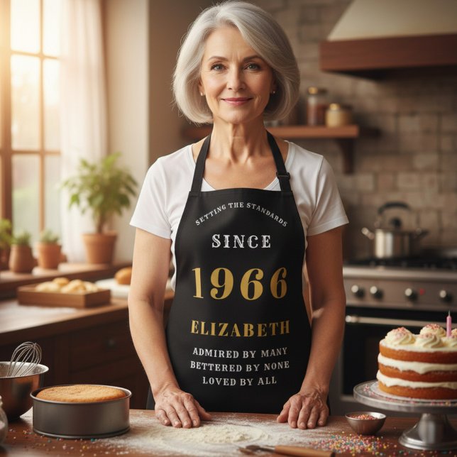 Tablier 60e anniversaire personnalisé 1966 noir et or (1966 birthday apron. Black and gold worn in a kitchen)