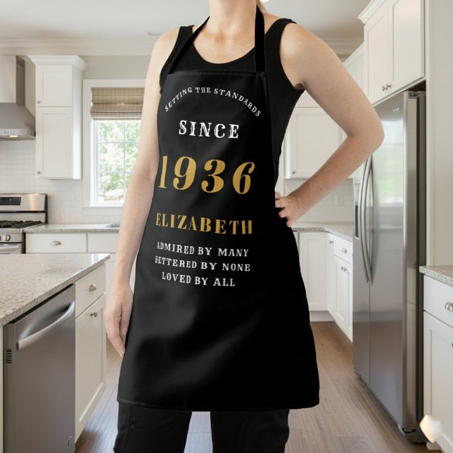 Tablier 90e anniversaire personnalisé 1936 Noir & Or (Apron born 1936 worn in a kitchen.)