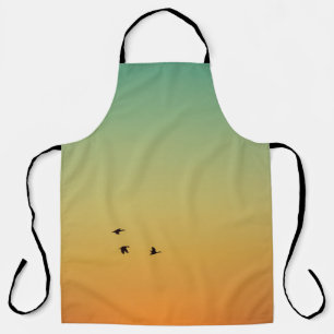 TABLIER SILHOUETTE D'OISEAUX VOLANT PENDANT LE COUCHER DU 