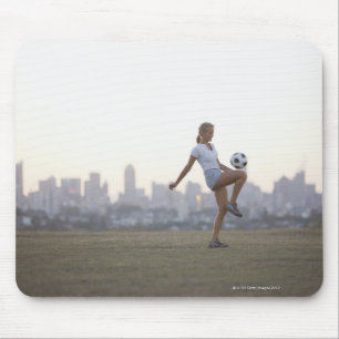 Tapis De Souris Une femme embrassant un ballon de football dans un