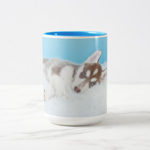 Tasse 2 Couleurs Petite marionnette Husky posée sur une couverture