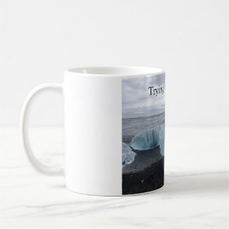 Tasse avec de la glace sur la plage noire
