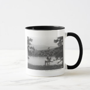 Tasse Bétail par un étang avec deux cowboys