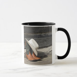 Tasse Casquette de cowboy sur des bottes de cowboy en