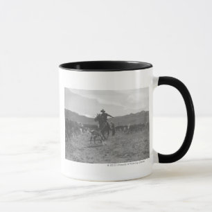 Tasse Cowboy roping un veau pour le marquage à chaud de
