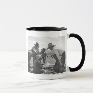 Tasse Cowboys regardant une magazine