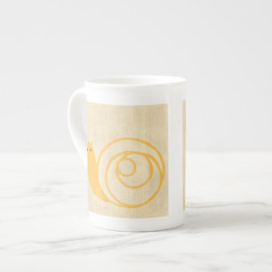 Tasse En Porcelaine Escargot jaune sur l'arrière - plan crème
