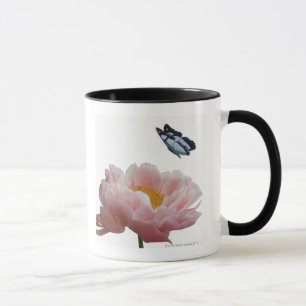 Tasse une grande pivoine rose est visitée par un éthé