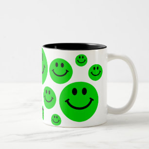 Tasse verte de visages