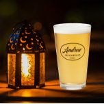 Taupe Stylized Wedding Groomsman Name Glass<br><div class="desc">Beer glass for the wedding groomsman that features his name printed in a taupe colour, stylized script inside a taupe colour oval border along with wedding date. A great party supply idea for a bachelor party! Personalize your beer glass by editing and replacing name and date with your own. Available...</div>