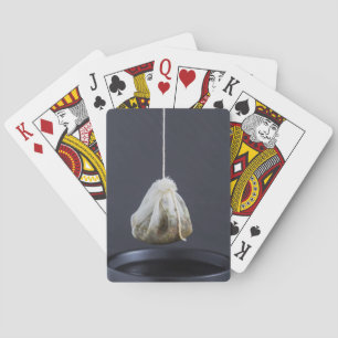 Tea bag is hung in a cup playing cards