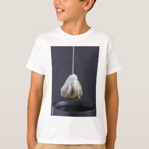 Tea bag is hung in a cup T-Shirt