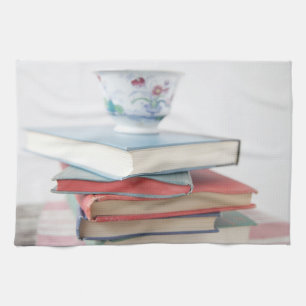 Teacup on book stack kitchen towel