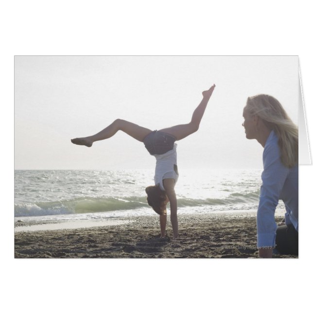Teenage girl performs gymnastic feat, mom (Front Horizontal)