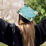 The Adventure Begins | Custom Class Year Graduation Cap Topper<br><div class="desc">Beautiful grad cap topper features the quote "And so the adventure begins" in white script lettering on a vibrant turquoise aqua background adorned with white watercolor flowers and green foliage. Personalize with your class year and/or school.</div>