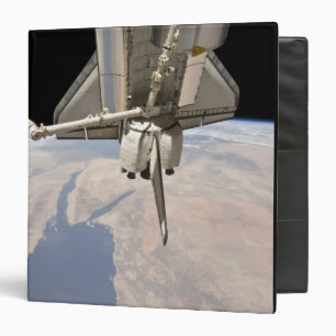 The aft section of the docked space shuttle binder