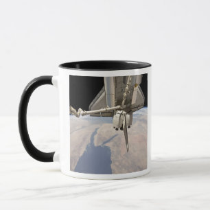 The aft section of the docked space shuttle mug
