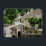The bridge in Castle Combe, UK text magnet<br><div class="desc">Rectangular magnet of the bridge over Bybrook River in the small,  quaint village of Castle Combe with houses built out of honey-coloured stone in the Cotswolds,  England,  UK with the text: 'Cotswolds'. A great souvenir!</div>