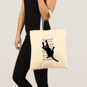 The cat hangs on musical notes tote bag