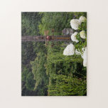 The Garden Where Time Stands Still Jigsaw Puzzle<br><div class="desc">A peaceful scene where white hydrangeas bloom against a lush green forest,  complemented by a vintage weather vane. Experience a quiet rest in a tranquil garden where the noise of daily life fades away.</div>