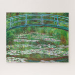 The Japanese Footbridge by Claude Monet Jigsaw Puzzle<br><div class="desc">The painting features a pale turquoise footbridge arching over a pond lined with tall grasses and filled with petal-pink and butter-yellow waterlilies spans this horizontal landscape painting. The scene is loosely painted with touches of vibrant colour. In the top third of the composition, the shallowly arched bridge nearly touches the...</div>