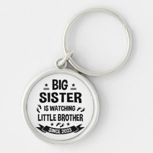 The little sister takes care of the big brother in keychain