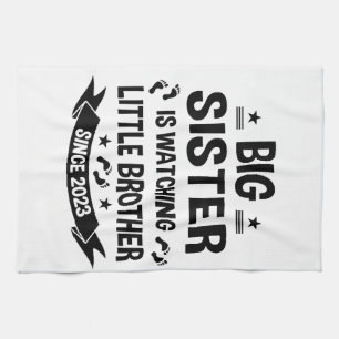The little sister takes care of the big brother in kitchen towel