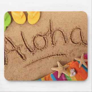 The word Aloha written on a sandy beach, with 2 Mouse Pad