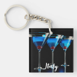 Three blue cocktails with cherry on black keychain