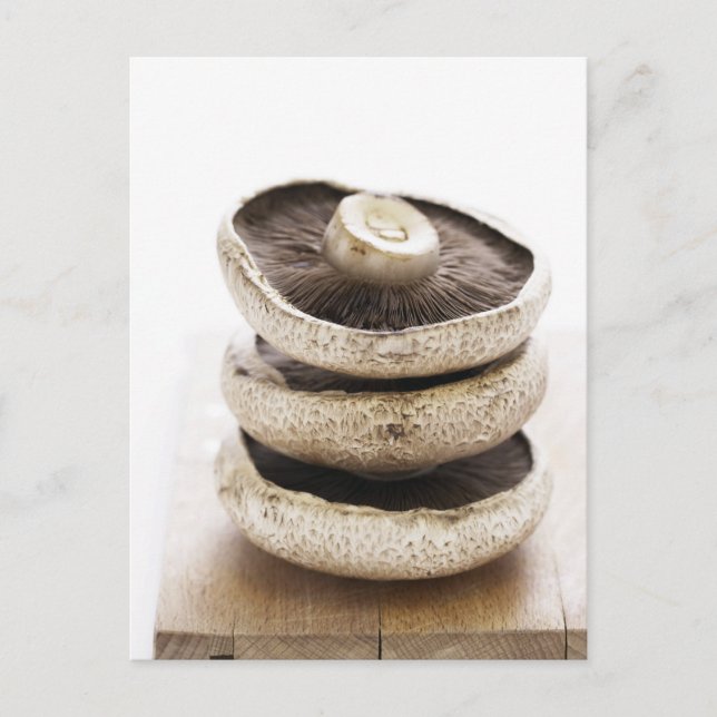 Three flat mushrooms in pile on wooden board postcard (Front)