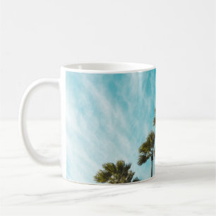 Three green leaf trees below cirus clouds coffee mug