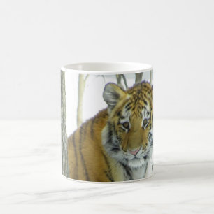Tiger Cub In Snow Peeking Around Tree Coffee Mug