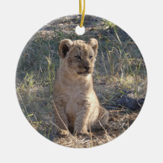 Tiny African lion cub sitting in the grass Ceramic Ornament