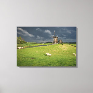 Toile Moutons avec moulins à vent sous des nuages sombr