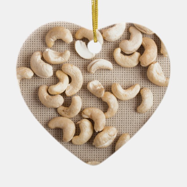 Top view on raw cashew nuts scattered on the table ceramic ornament (Front)