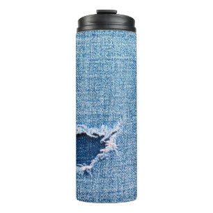 Torn denim fabric texture, blue hues. thermal tumbler
