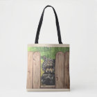 Tote with cute dog peeking between fence slats