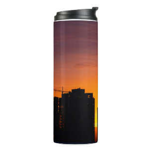Tower cranes silhouetting beautiful sunset thermal tumbler