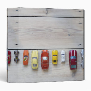 Toy cars lined up in a row on floor binder