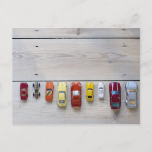 Toy cars lined up in a row on floor postcard