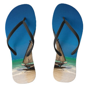 Traditional fishing boat on the beach flip flops