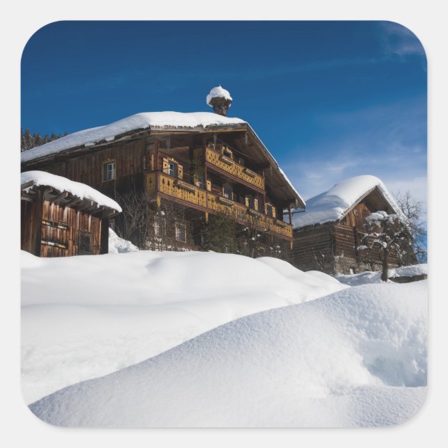 Traditional wooden cabins in de snow square sticker (Front)