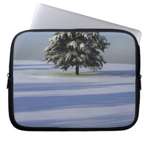 Tree in snow covered landscape laptop sleeve