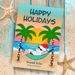 Tropical Beach Santa Hammock Christmas Holiday Card<br><div class="desc">Tropical and coastal theme Christmas card features Santa relaxing in a hammock on the beach, enjoying the ocean waves and a colorful sunset and festive palm trees decked out in string lights. The top greeting says "Happy Holidays" in navy blue. The greeting in the sand and the name can be...</div>