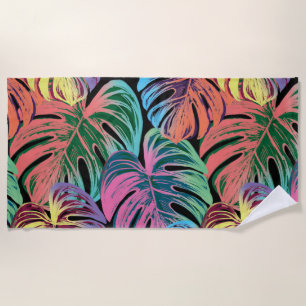 Tropical colourful monstera leaf on black  beach towel