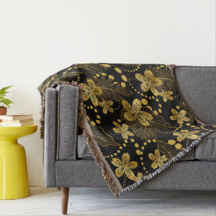 tropical leaves & flowers pattern in gold on black throw blanket