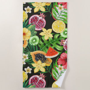 Tropical mix-fruit, flowers and leaves on black beach towel