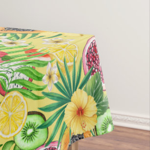 Tropical mix-fruit, flowers and leaves on yellow tablecloth